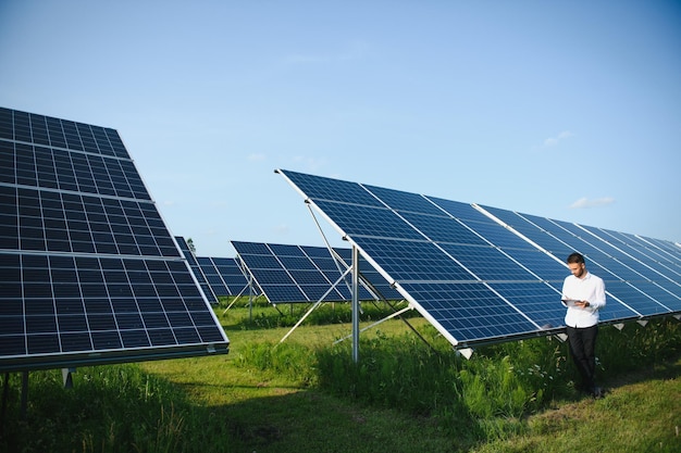 Impianto di energia solare lavoratore maschio su uno sfondo di pannelli fotovoltaici