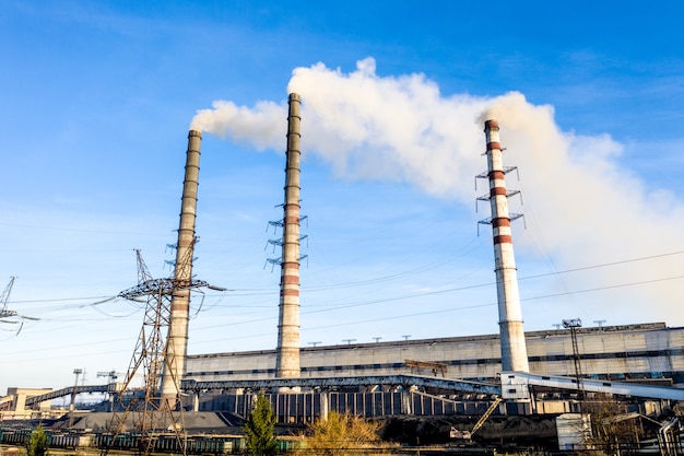 Impianto elettrico pesante alimentato a carbone industriale con tubi e fumo in bianco e nero