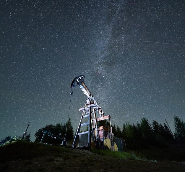 Impianto petrolifero di sera sotto il cielo stellato