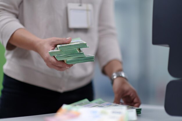 Impiegati della banca che utilizzano la macchina per contare i soldi mentre smistano e contano le banconote di carta all'interno del caveau della banca. Grandi somme di denaro in banca