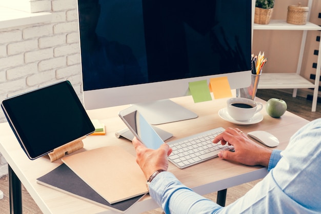 Impiegato che fa il suo lavoro seduto al suo tavolo di lavoro con un computer