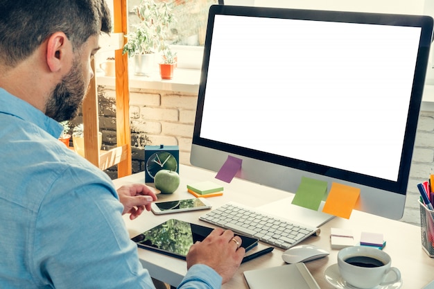 Impiegato che fa il suo lavoro seduto al suo tavolo di lavoro con un computer