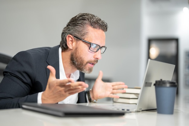 Impiegato con laptop in ufficio Impiegato in ufficio che lavora a distanza in un ufficio moderno ha sorpreso gli affari