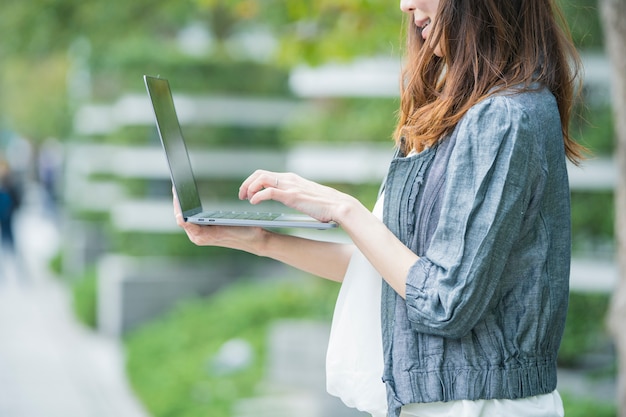 Impiegato femminile asiatico con il computer portatile