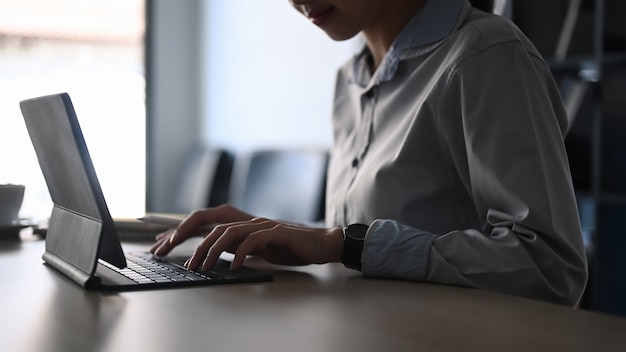 Impiegato femminile che lavora al tavolo del computer nella stanza dell'ufficio.