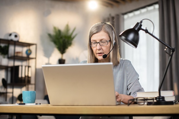 Impiegato remoto seduto con il computer portatile alla scrivania sul posto di lavoro