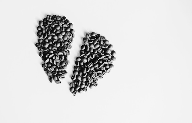 Impilare i chicchi di caffè su sfondo bianco e vista dall'alto di texture