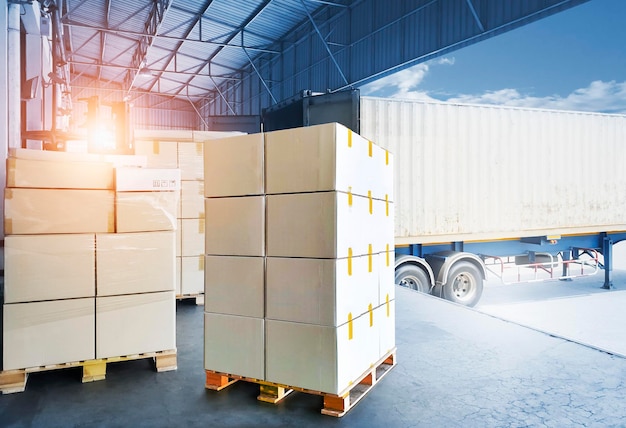 Impilati di scatole di imballaggio che caricano con la spedizione di camion portacontainer che caricano al magazzino del molo