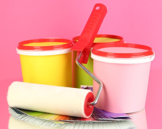 Impostare per la pittura di vasi di vernice tavolozza rullo di colori su sfondo rosa
