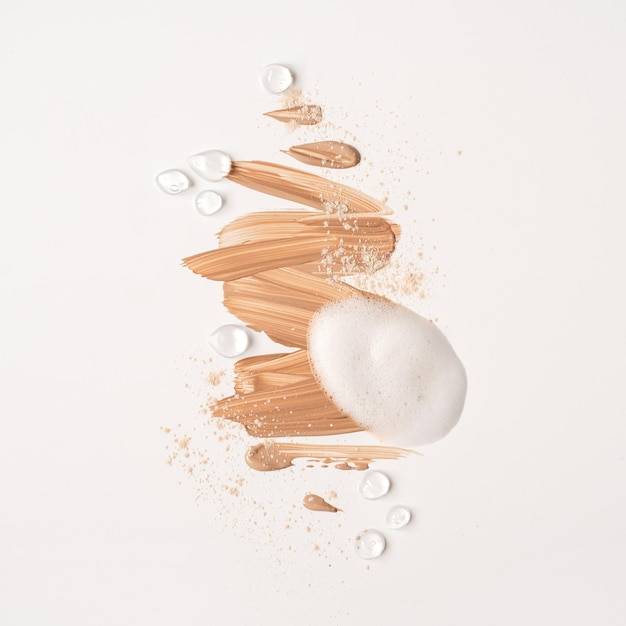 Impostazione dei prodotti di bellezza per la cura della pelle Striscio di crema cosmetica beige isolato su sfondo bianco Polvere di schiuma di bellezza bianca