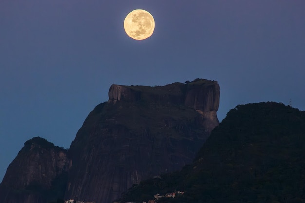 Impostazione della luna piena in cima alla pietra di Gavea vista dalla laguna Rodrigo de Freitas a Rio de Janeiro