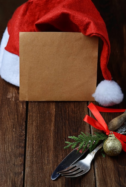 Impostazione posto tavola di Natale, carta vuota e cappello di Babbo Natale