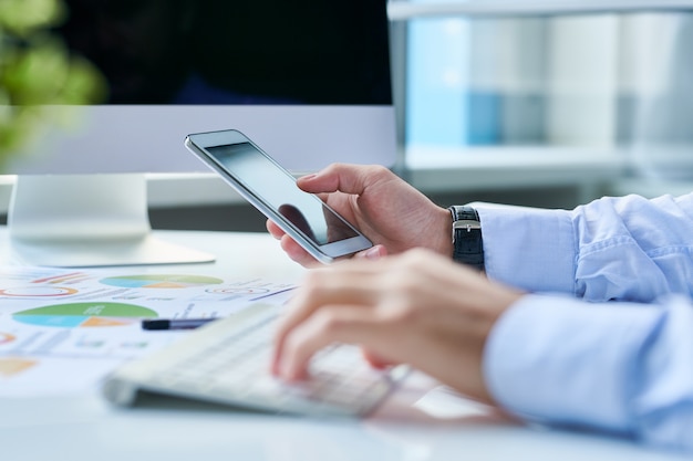 Imprenditore agricolo con smartphone sul posto di lavoro