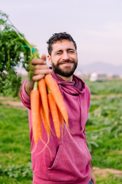 Imprenditore agricoltore che mostra un fascio di carote