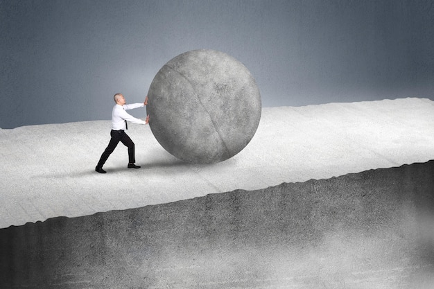Imprenditore che spinge una grande pietra su una collina Imprenditori con compiti pesanti e problemi