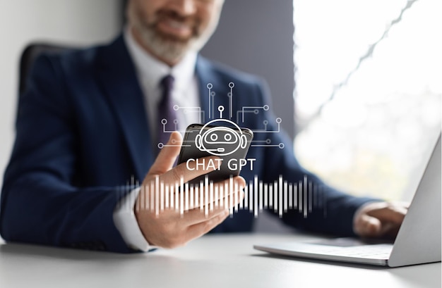 Imprenditore che utilizza l'icona chat gpt sull'interno dell'ufficio dello smartphone
