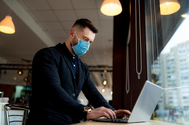 Imprenditore di successo che lavora in maschera medica Lavoro al chiuso in quarantena Ritratto maschile in maschera