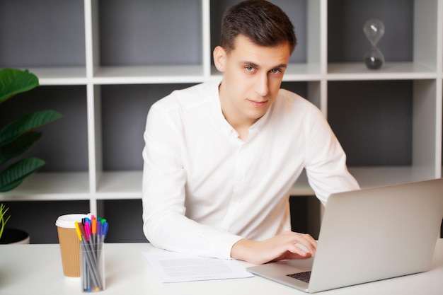 Imprenditore di successo che lavora in ufficio al computer portatile.