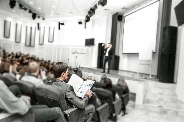 Imprenditore di successo con documenti finanziari seduto in una sala conferenze per presentazioni aziendali