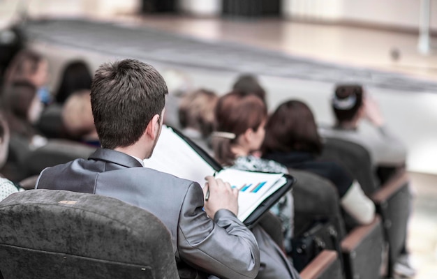 Imprenditore di successo con documenti finanziari seduto in una sala conferenze per presentazioni aziendali