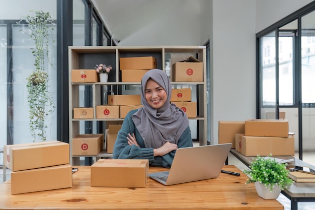 imprenditore donna musulmana sorridente proprietaria che prepara il prodotto per il cliente piccolo negozio di e-commerce online