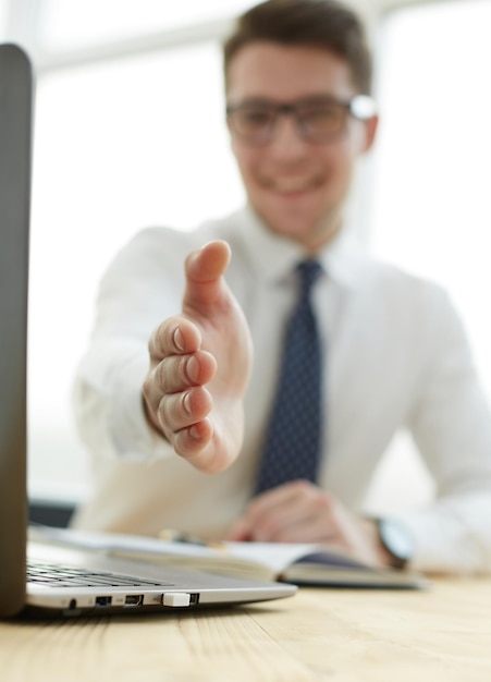 Imprenditore estendendo la mano per stringere in ufficio