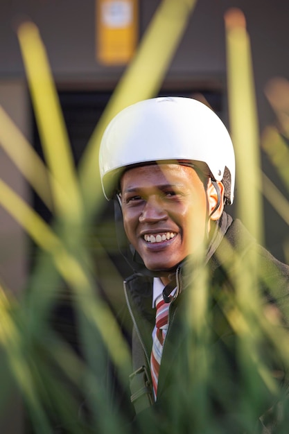 Imprenditore etnico latino con casco da bicicletta sorridente guardando la fotocamera