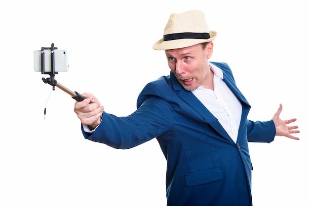 Imprenditore maturo tenendo selfie stick e scattare foto selfie