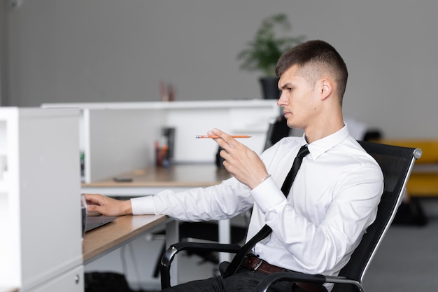 Imprenditore seduto al lavoro guardando laptop Concetto di lavoro d'ufficio