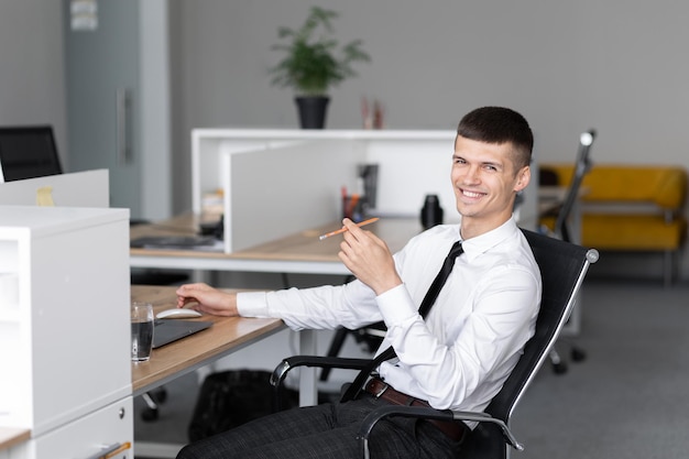 Imprenditore seduto al lavoro guardando laptop Concetto di lavoro d'ufficio