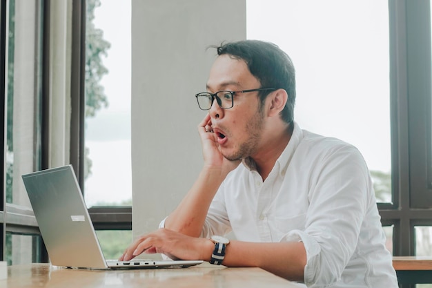 Imprenditore sorpreso guardando lo schermo del laptop impiegato maschio che soffre di problemi di business mentre lavora online sul computer in ufficio