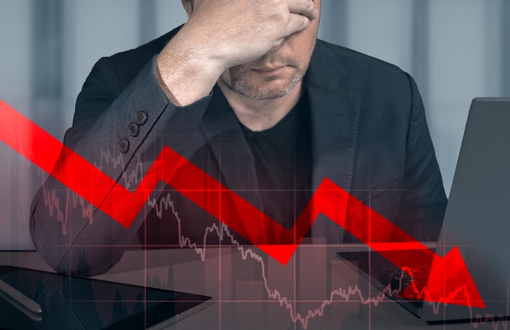 Foto imprenditore tenendo le mani sulla testa guardando il grafico del profitto in calo imprenditore guardando il grafico che indica la caduta dei grafici del dollaro che rappresentano il crollo del mercato azionario causato