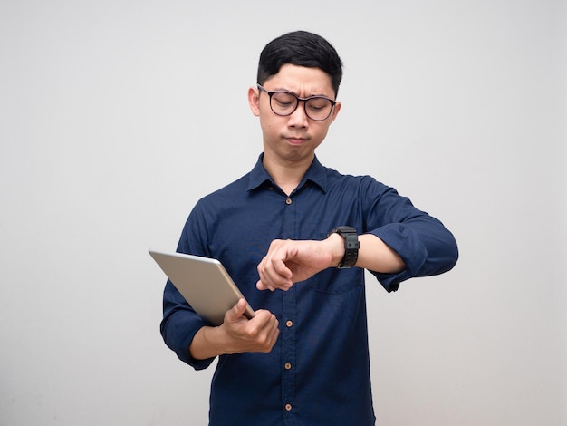 Imprenditore tenere tablet guardando il suo orologio fretta emozione isolata