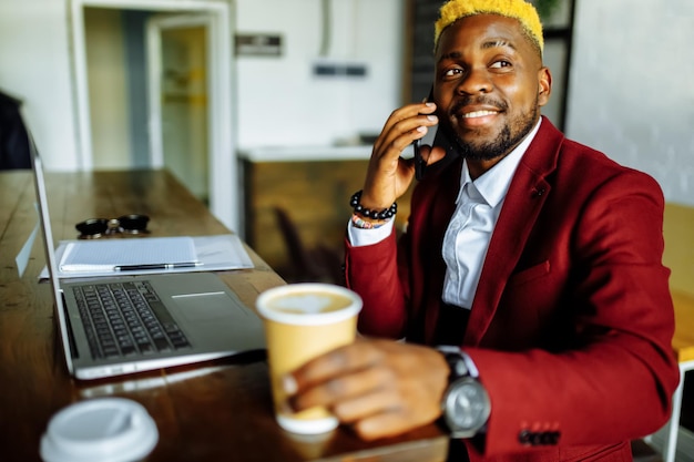 Imprenditore uomo d'affari allegro parlando telefono cellulare e scrivendo una nota in ufficio