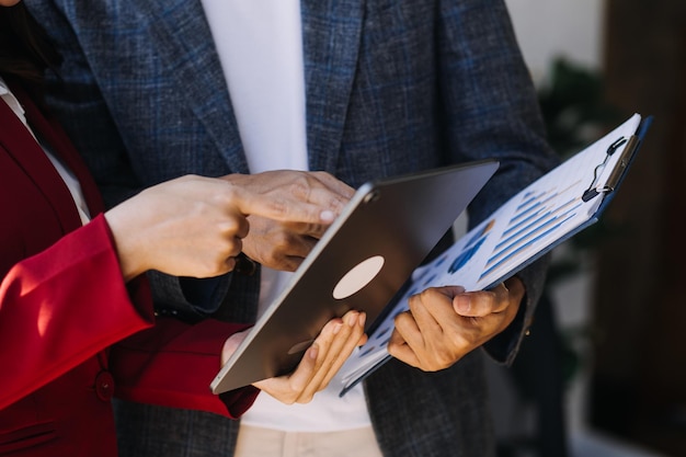 Imprenditore uomo d'affari asiatico e donna d'affari che discutono di un nuovo progetto di business in tablet nel moderno Meeting In Modern Office Business asiatico concetto casual