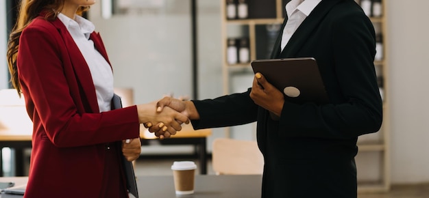 Imprenditore uomo d'affari asiatico e donna d'affari che discutono di un nuovo progetto di business in tablet nel moderno Meeting In Modern Office Business asiatico concetto casual