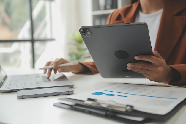 Imprenditore uomo d'affari asiatico e donna d'affari che discutono di un nuovo progetto di business in tablet nel moderno Meeting In Modern Office Business asiatico concetto casual