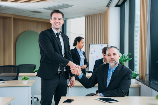 Imprenditori che si stringono la mano nello spazio di lavoro Imprenditori di successo che si stringono la mano