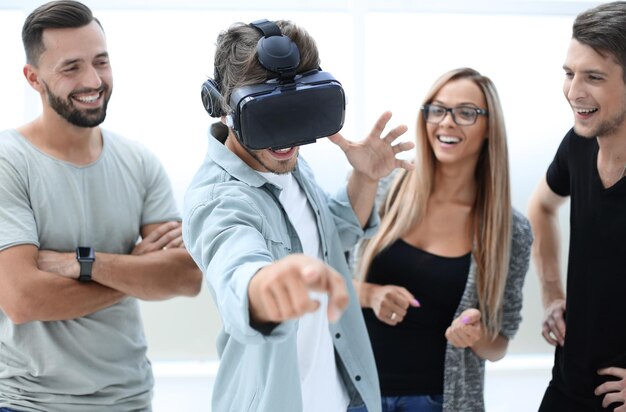 Imprenditori che testano la tecnologia della realtà virtuale con un collega in ufficio