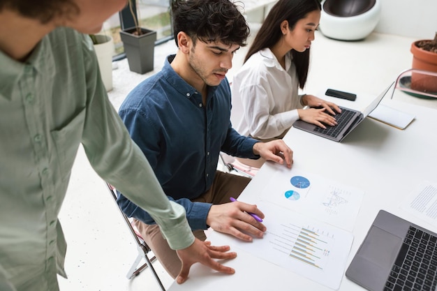 Imprenditrice afroamericana che controlla i colleghi lavorano in un ufficio moderno