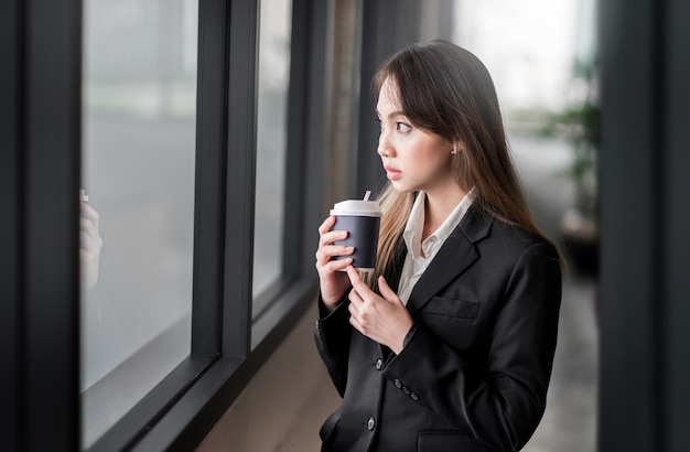 imprenditrice bere caffè nel morring con sfondo sfocato