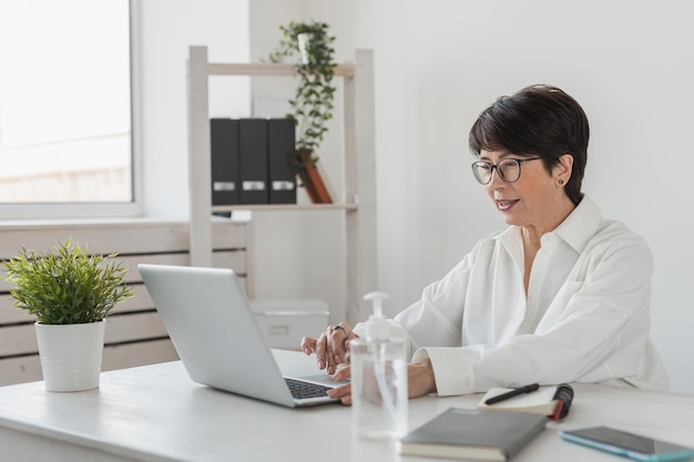 Imprenditrice che lavora in ufficio facendo videochiamata con il laptop Professionista femminile che fa videochiamata