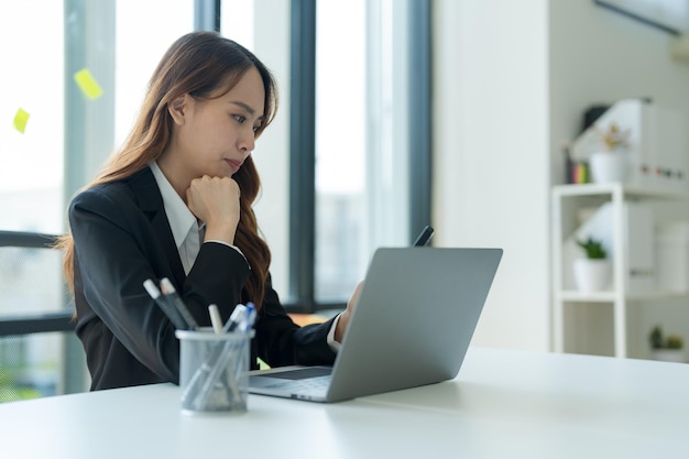 Imprenditrice che lavora su un computer portatile per informazioni aziendali in ufficio