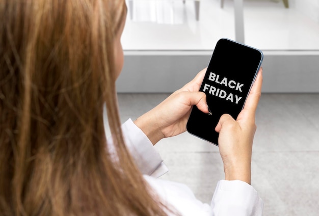 Imprenditrice che mostra il testo del Black Friday sullo schermo del telefono cellulare