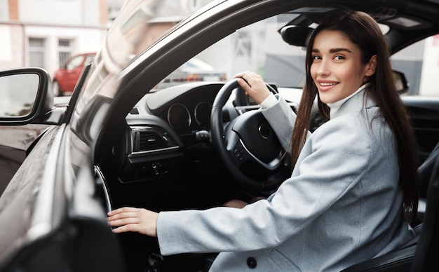 Imprenditrice di successo che esce dall'auto e sorridente Dirigente femminile che entra nel veicolo per guidare al lavoro