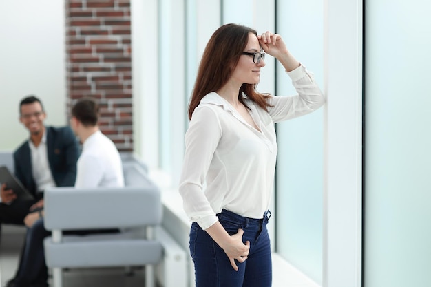 Imprenditrice di successo guardando attraverso la finestra dell'ufficio