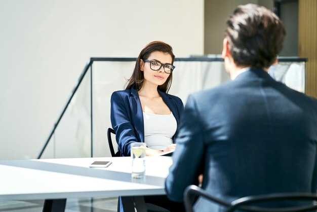 Imprenditrice e uomo d'affari parlando alla scrivania in un ufficio moderno