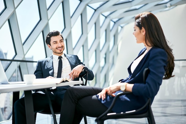 Imprenditrice e uomo d'affari parlando alla scrivania in un ufficio moderno