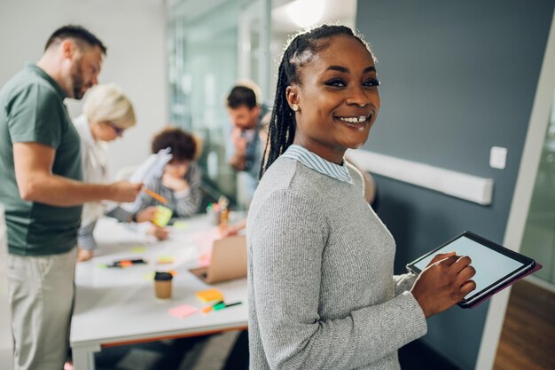 Imprenditrice in posa e sorridente durante una riunione in un ufficio