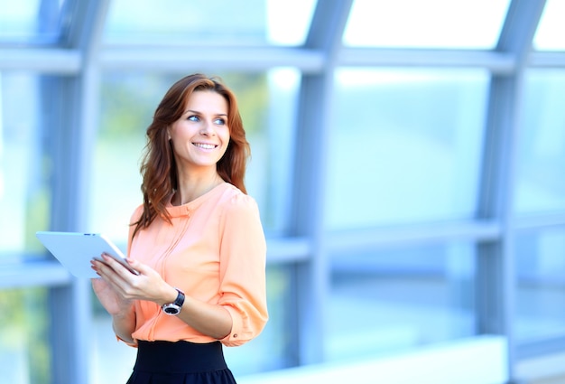 Imprenditrice lavorando su tavoletta digitale all'aperto su sfondo di costruzione